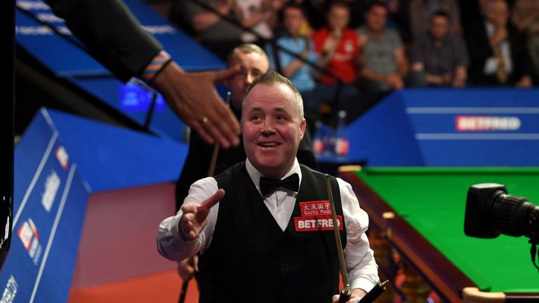 John Higgins celebrates after beating Martin Gould during their first round match of the World Snooker Championship