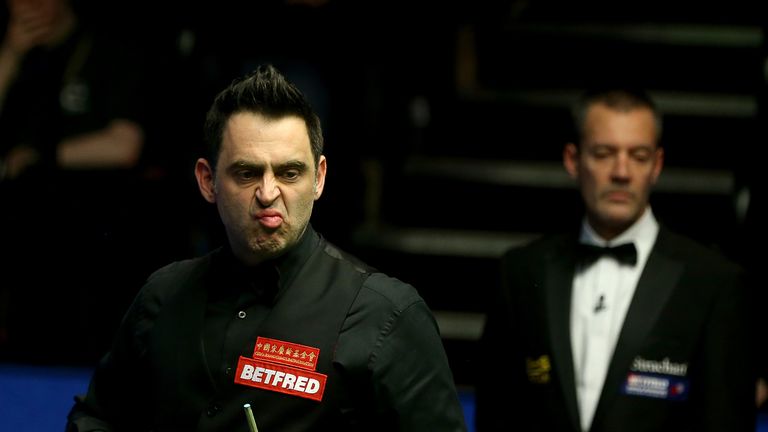 Ronnie O'Sullivan reacts after playing a shot against Shaun Murphy during their second round match of the World Snooker Championship