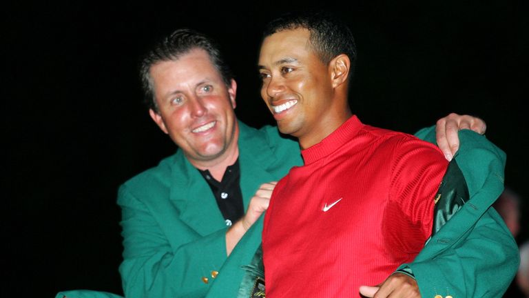 AUGUSTA, GA - APRIL 10:  Tiger Woods smiles as he is presented with the green jacket by Phil Mickelson after Woods won The Masters at the Augusta National 