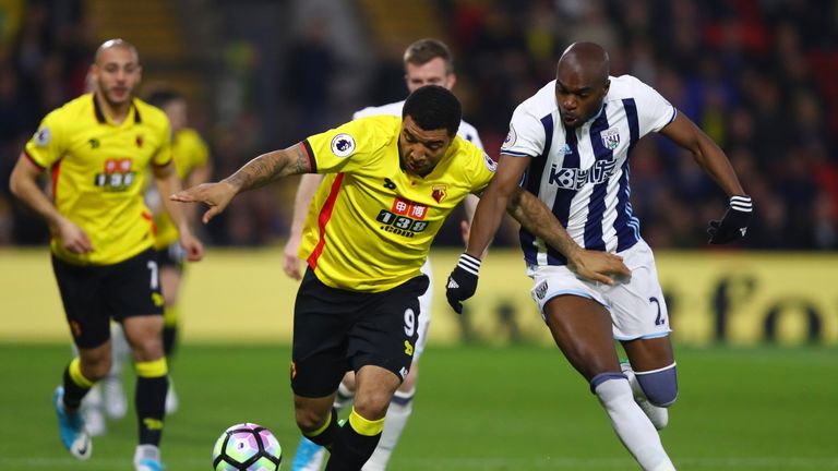 Troy Deeney tussles with Allan Nyom during the early stages at Vicarage Road