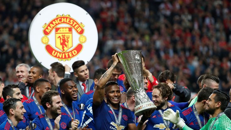 Manchester United's players including Ecuadorian midfielder Antonio Valencia (C) celebrate with the trophy after the UEFA Europa League final against Ajax