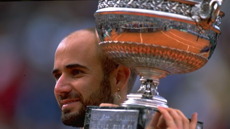 Andre Agassi of the United States celebrates victory with the trophy during the 1999 French Open Final match against Andrei Medvedev