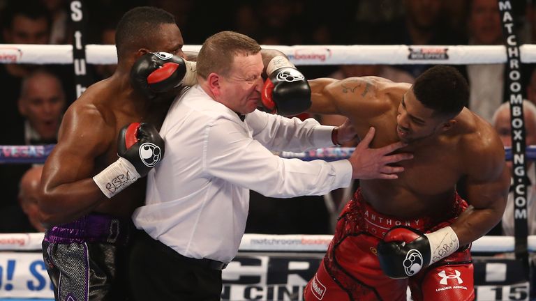 TOPSHOT - Referee Howard Foster (C) tries to separate British boxer Dillian Whyte (L) and British boxer Anthony Joshua (R) after the bell had rang in round