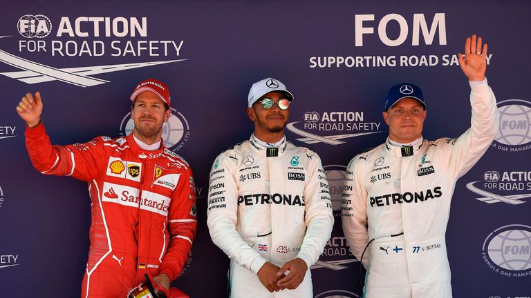 (L to R) Ferrari's German driver Sebastian Vettel, Mercedes' British driver Lewis Hamilton and Mercedes' Finish driver Valtteri Bottas celebrate in the par