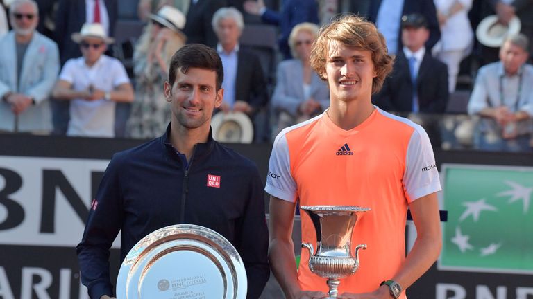 Alexander Zverev of Germany (R) poses with the trophy after winning the ATP Tennis Open final against Novak Djokovic (L) of Serbia on May 21, 2017, at the 