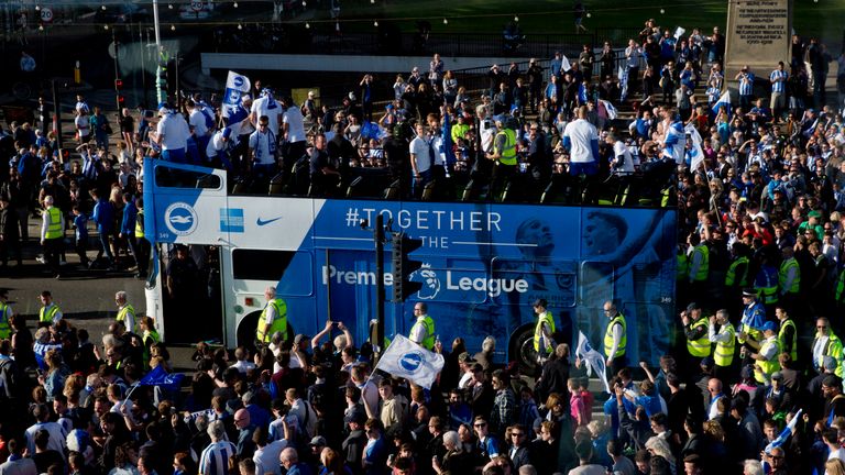 Brighton and Hove Albion football fans cheer their team during the bus parade through Brighton.