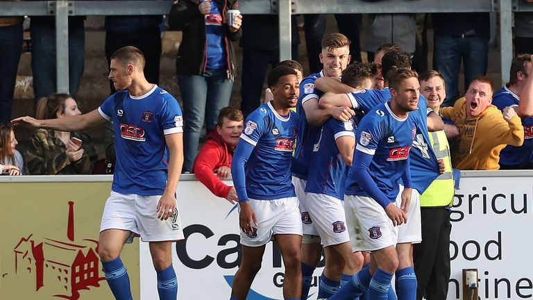 Carlisle United players celebrate with Shaun Miller as he scores his team's third goal v Exeter during the Sky Bet League Two play-off semi-final first leg