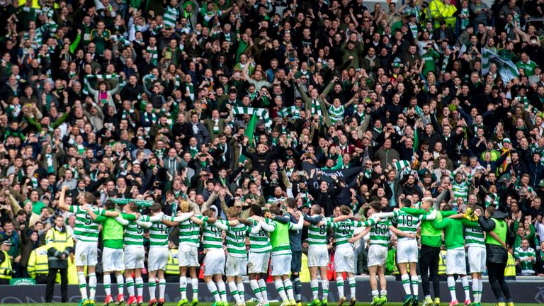Celtic's players celebrate with the fans at full time at Ibrox