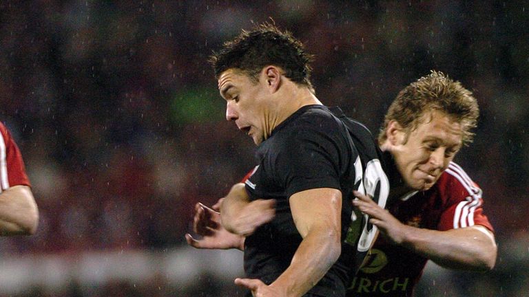 Dan Carter clears the ball as he is tackled by Jonny Wilkinson 