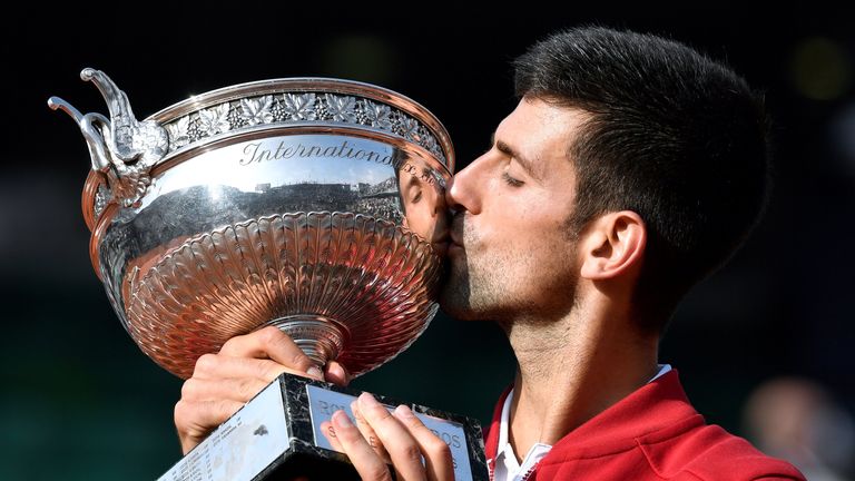 Serbia's Novak Djokovic holds the trophy after winning the men's final match against Britain's Andy Murray at the Roland Garros 2016 French Tennis Open in 