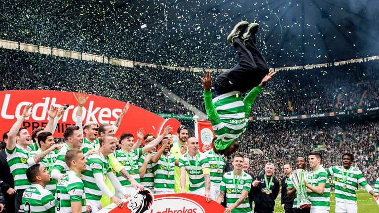 Celtic's Efe Ambrose performs a backflip off the stage amidst the celebrations