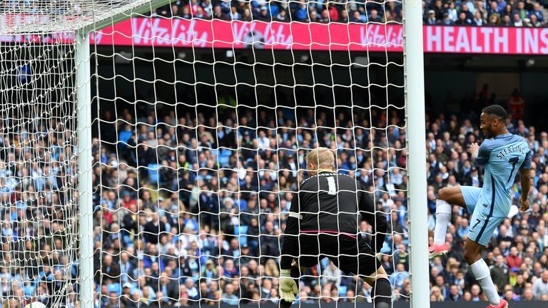 Manchester City's English midfielder Raheem Sterling (R) is seen as Leicester City's Danish goalkeeper Kasper Schmeichel (2R) watches the ball go into his 