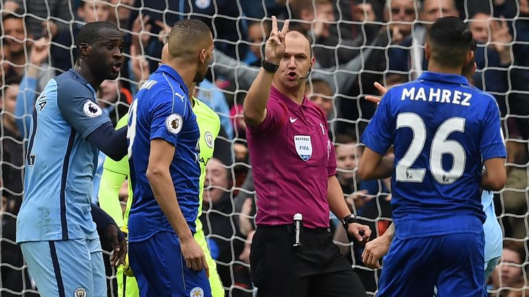 English referee Robert Madley (2nd R) explains to Leicester City's Algerian midfielder Riyad Mahrez (R) that his penalty hit his standing foot on the way t