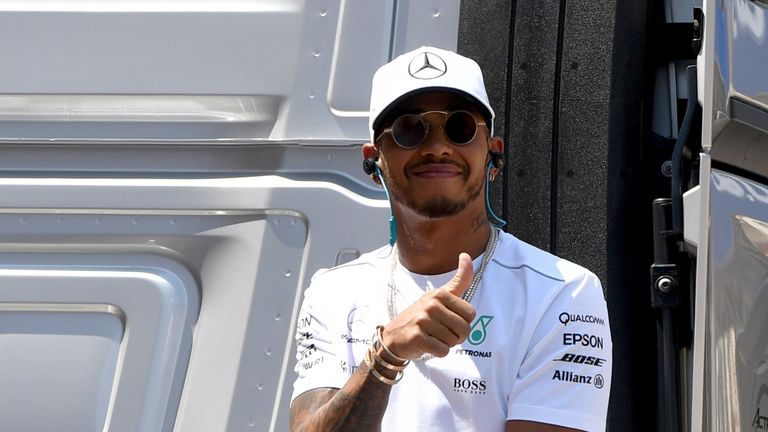 Mercedes' British driver Lewis Hamilton gives a thumbs up as he sits on a truck during the drivers parade at the Monaco street circuit, on May 28, 2017 in 
