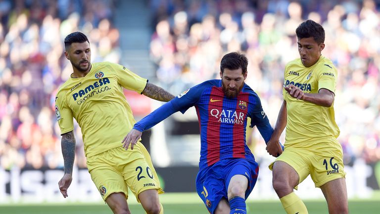 Lionel Messi is closed down by Rodrigo Hernandez (R) and Roberto Soriano at the Camp Nou