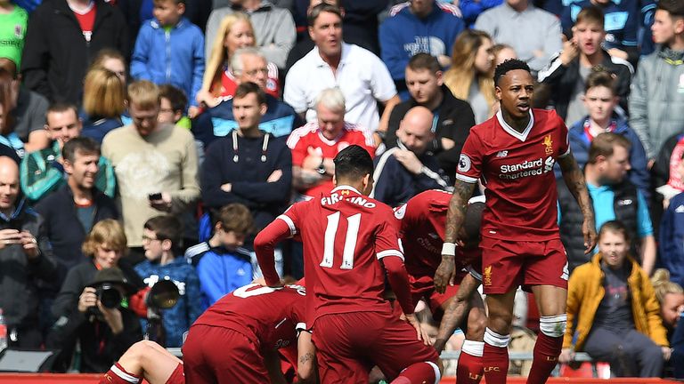 Liverpool's English midfielder Adam Lallana (unseen) is mobbed by teammates after scoring his team's third goal during the English Premier League football 
