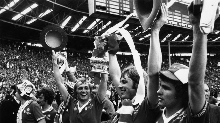 21st May 1977:  Brian Greenhoff (centre) lifting the FA Cup with his brother Jimmy who scored Manchester United's second and winning goal in the final agai