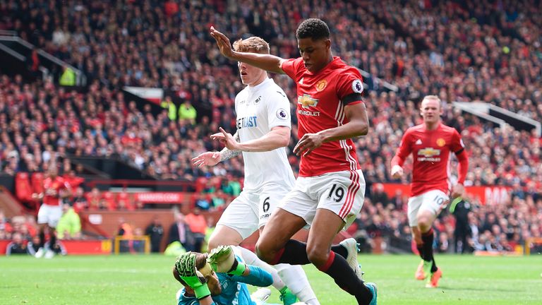 Marcus Rashford goes down under a challenge from Lukasz Fabianski to earn a penalty at Old Trafford