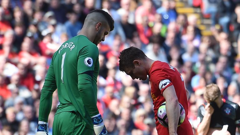 Southampton's English goalkeeper Fraser Forster (L) eyes up Liverpool's English midfielder James Milner before he takes a penalty during the English Premie