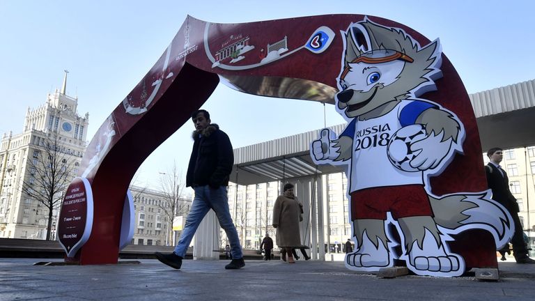 A man walks through a Confederations Cup 2017-themed arch decorated with an image of Zabivaka, the mascot for the 2018 World Cup, in central Moscow