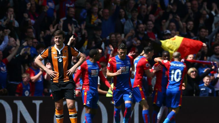 Harry Maguire of Hull City looks dejected as Crystal Palace players celebrate their first goal during the Premier League match, scored by Wilfried Zaha