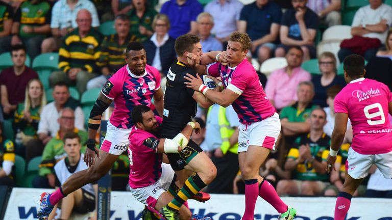George North  is tackled by Stade Francais duo Geoffrey Doumayrou and Jules Plisson (right)