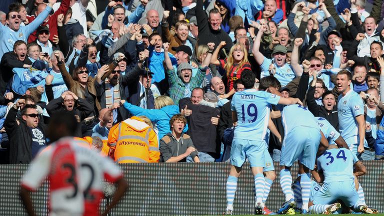 Manchester City's Argentinian striker Sergio Aguero celebrates his late winning goal with team-mates during the English Premier League football match betwe