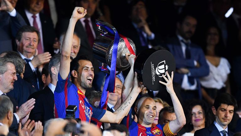 MADRID, SPAIN - MAY 27:  Sergio Busquets (L) and Andres Iniesta of FC Barcelona hold up the trophy after winning the Copa Del Rey Final between FC Barcelon