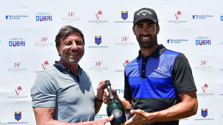 SCIACCA, ITALY - MAY 18:  Sir Rocco Forte presents Alvaro Quiros of Spain with a bottle of champagne for his hole in one on the 13th hole during the first 
