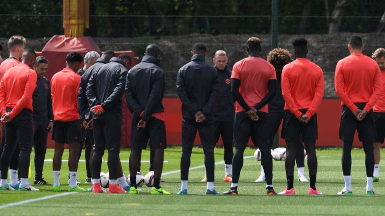 Manchester United's English striker Wayne Rooney (7R) stands with teammates as they observe a minute's silence for victims of yesterday's terror attack at 