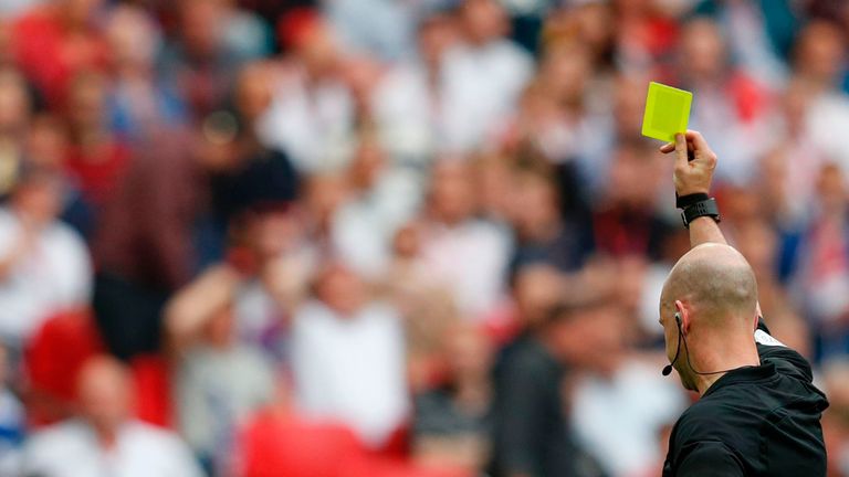 Chelsea's Nigerian midfielder Victor Moses (L) looks up as English referee Anthony Taylor shows him his second yellow card of the game