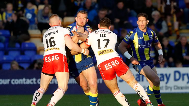 Warrington Wolves' Mike Cooper is tackled by St Helens Luke Thompson (left) and Tommy Lee (right) during the Betfred Super League match at the Halliwell Jo