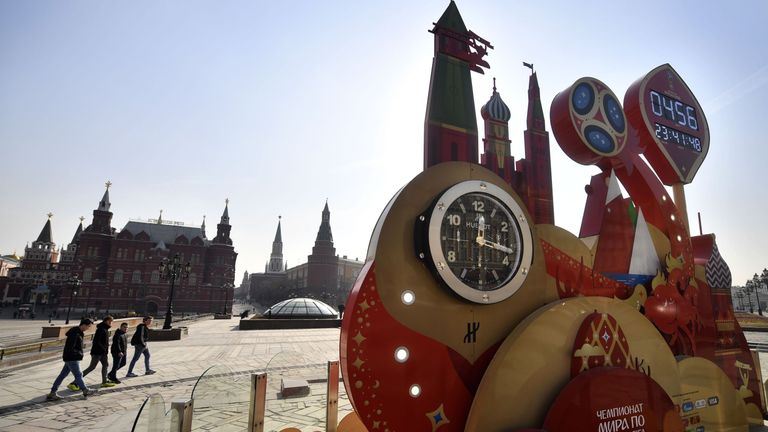 Youths walk past World Cup 2018-themed decorations at Moscow's Manezhnaya square on March 14, 2017