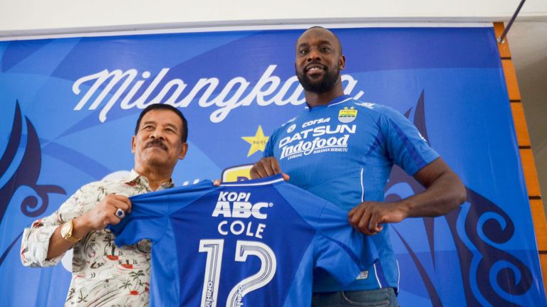 Former West Ham United and Chelsea striker Carlton Cole and Persib manager Umuh Muhtar hold Cole's jersey during a press conference in March 2017