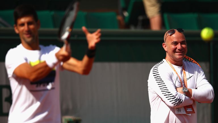 Andre Agassi watches on as Novak Djokovic prepares at Roland Garros