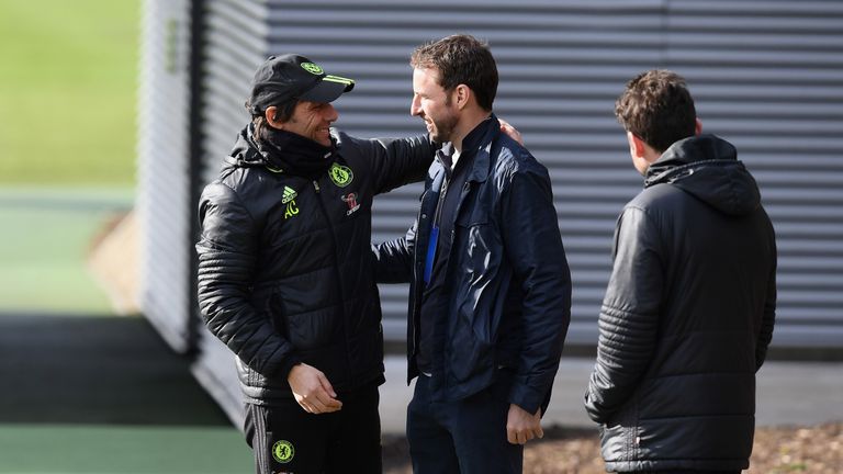 Antonio Conte talks to England manager Gareth Southgate before a training session at Chelsea's training ground in Cobham on February 16, 2017