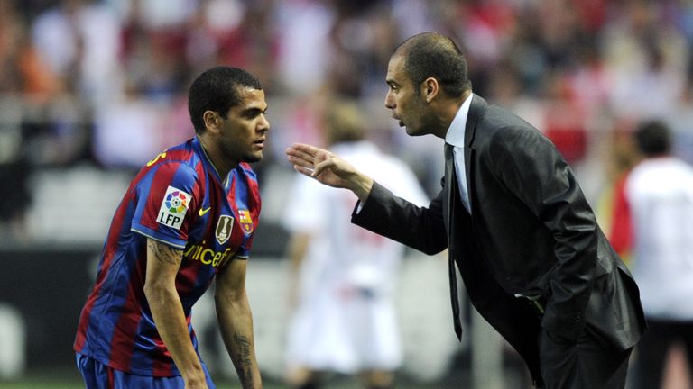 Barcelona's coach Pep Guardiola (R) speaks with Barcelona's Brazilian defender Dani Alves (L) during their Spanish league football match beetwen Sevilla an