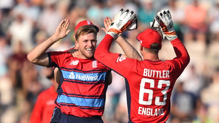 England's David Willey (L) celebrates with England's Jos Buttler after bowling South Africa's JJ Smuts with the first ball of the T20 international cricket