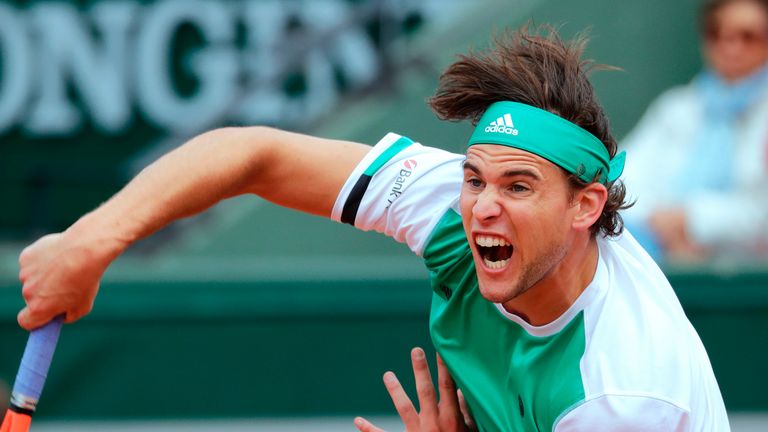 Dominic Thiem returns the ball to Novak Djokovic during the French Open at Roland Garros