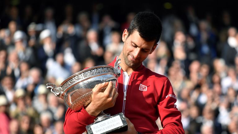Serbia's Novak Djokovic holds the trophy after winning the men's final match against Britain's Andy Murray at the Roland Garros 2016 French Tennis Open in 