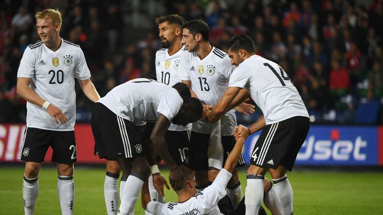 Germany's defender Joshua Kimmich is helped by his temmates for cram after scoring during the friendly football match between Denmark and Germany