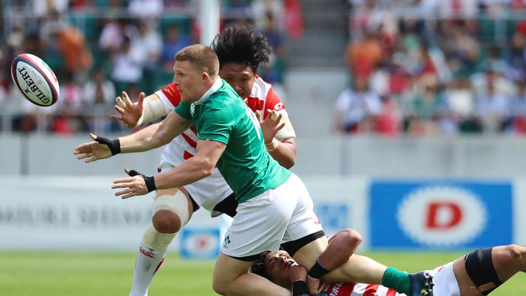 Ireland's Andrew Conway offloads under pressure during the Test match in Shizuoka