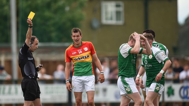 Referee Niall Cullen shows a second yellow card card to Jarlath Branagan of London, second right, during the match between London and Carlow
