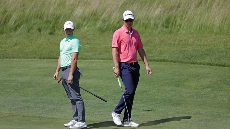 Rory McIlroy of Northern Ireland (L) and Justin Rose of England walk across the fifth green