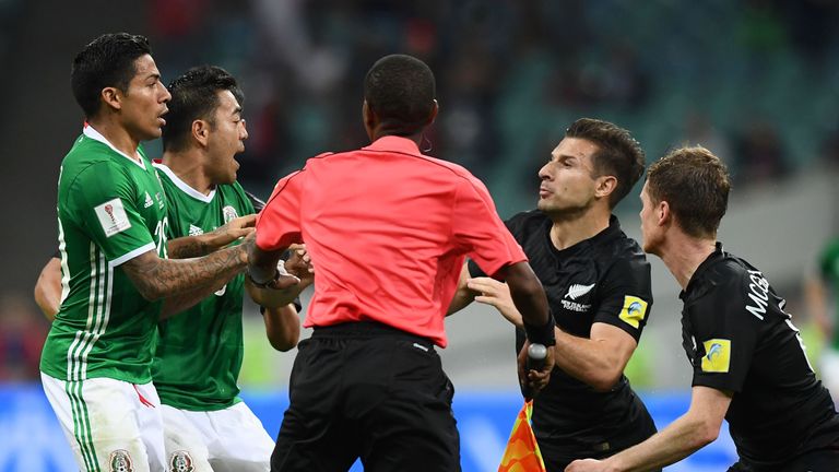 A referee attempts to separate players fighting during the 2017 Confederations Cup group A football match between Mexico and New Zealand at the Fisht Stadi
