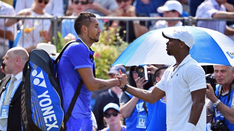 Australia's Nick Kyrgios (L) shakes hands with Donald Young of the US after having to retire