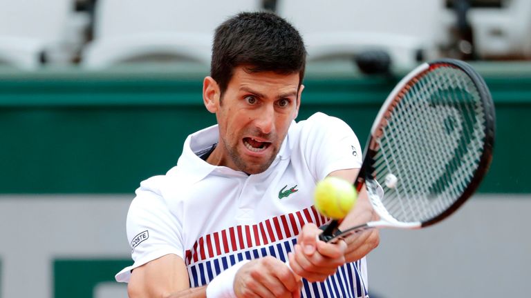 Novak Djokovic returns the ball to Dominic Thiem during their French Open match at Roland Garros