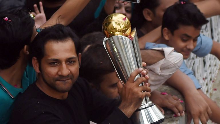 Pakistan skipper Sarfraz Ahmed holds the ICC Champions Trophy aloft to fans in Karachi