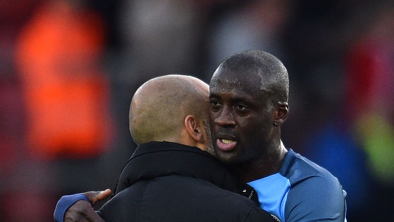 Pep Guardiola (L) embraces Manchester City midfielder Yaya Toure