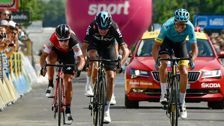 Denmark's Jakob Diemer Fuglsang (R) crosses the finish line ahead of Australia's Richie Porte (L) and Great Britain's Christopher Froome (C) at the end of 